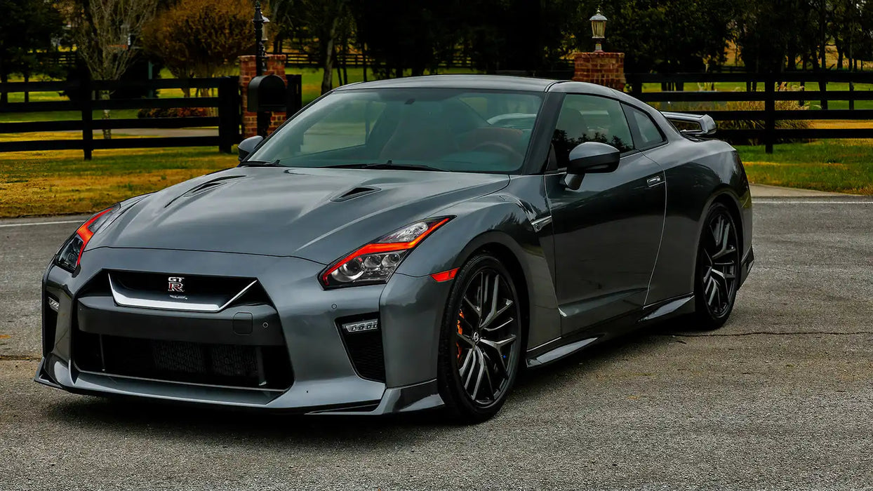 Three quarters view of a silver Nissan GT-R with red headlight DRLs.