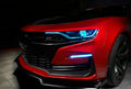 Front end of a red Chevrolet Camaro with cyan headlight DRLs.