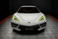 Front view of a white C8 Corvette with yellow headlight DRLs.