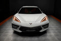 Front view of a white C8 Corvette with amber headlight DRLs.