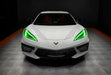 Front view of a white C8 Corvette with green headlight DRLs.
