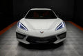 Front view of a white C8 Corvette with white headlight DRLs.