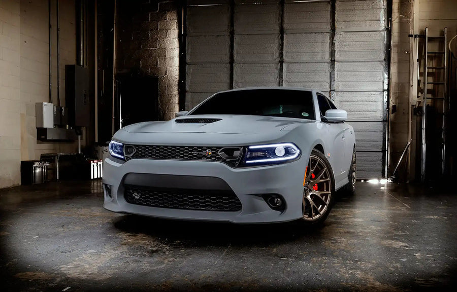 Three quarters view of a grey Dodge Charger with white headlight DRLs.