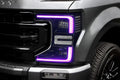 Close-up of a Ford Superduty headlight with pink DRLs.