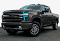 Three quarters view of a Chevy Silverado with cyan headlight DRLs.