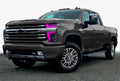 Three quarters view of a Chevy Silverado with pink headlight DRLs.