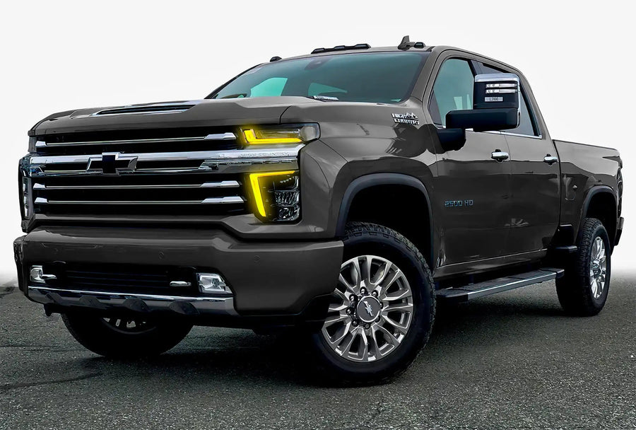 Three quarters view of a Chevy Silverado with yellow headlight DRLs.