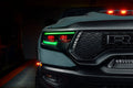 Close-up of Ram 1500 headlights with green DRLs and red demon eye projectors.