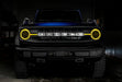 Front view of a blue Ford Bronco with yellow halos and DRLs.