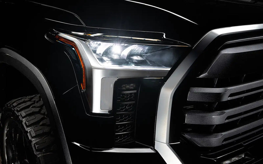 Close-up of a 2022+ Toyota Tundra headlight module installed with white demon eye projector.