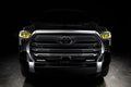  Straight front view of a black Toyota Tundra with yellow demon eye projectors.