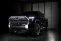 Three quarters view of a black Toyota Tundra with white demon eye projectors.