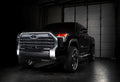 Three quarters view of a black Toyota Tundra with red demon eye projectors.