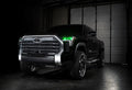 Three quarters view of a black Toyota Tundra with green demon eye projectors.
