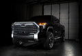 Three quarters view of a black Toyota Tundra with amber demon eye projectors.