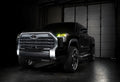 Three quarters view of a black Toyota Tundra with yellow demon eye projectors.