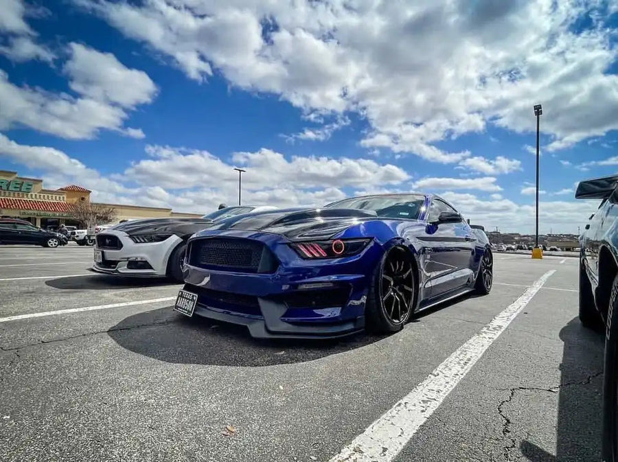 Three quarters view of a Ford Mustang with red headlight halos and DRLs.