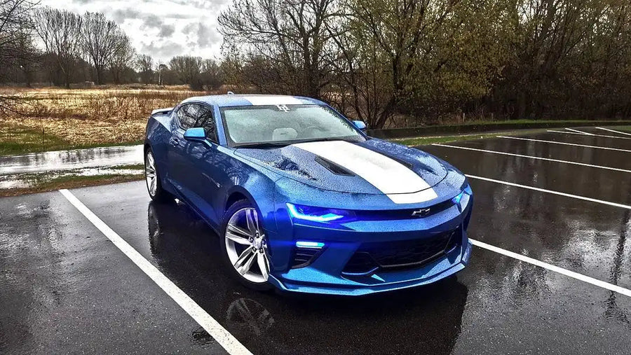 Three quarters view of a Chevrolet Camaro with blue headlight and fog light DRLs.