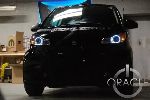 Smart Car with white LED headlight halo rings installed.