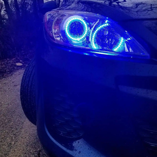 Close-up of Mazda 3 headlight with blue LED halo rings installed.