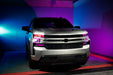 Silver Chevrolet Silverado with pink demon eye projectors and DRLs.