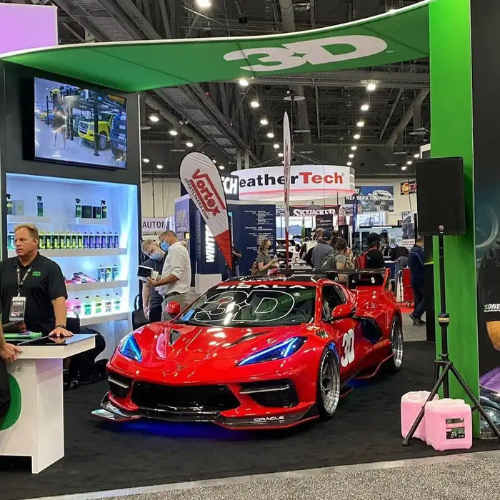 Red C8 Corvette in a showroom with blue headlight DRLs.