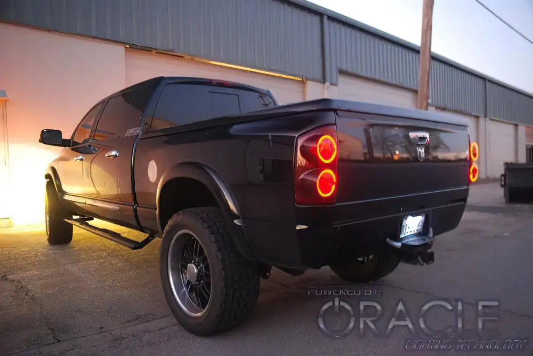 Rear three quarters view of a Dodge Ram with red LED tail light halo rings installed.