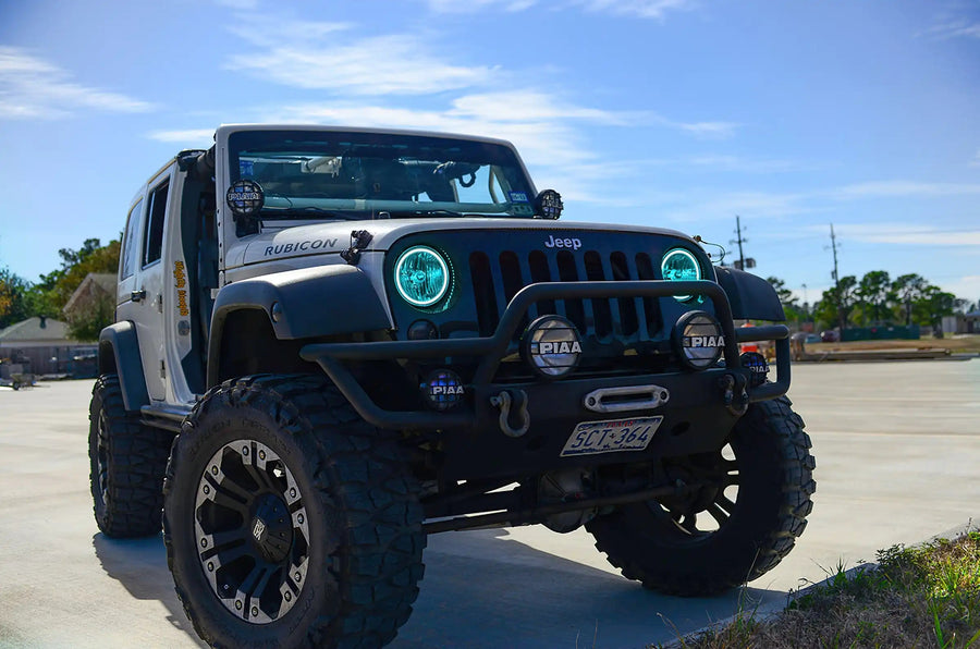 Three quarters view of a Jeep Wrangler JK with cyan LED headlight halos installed.