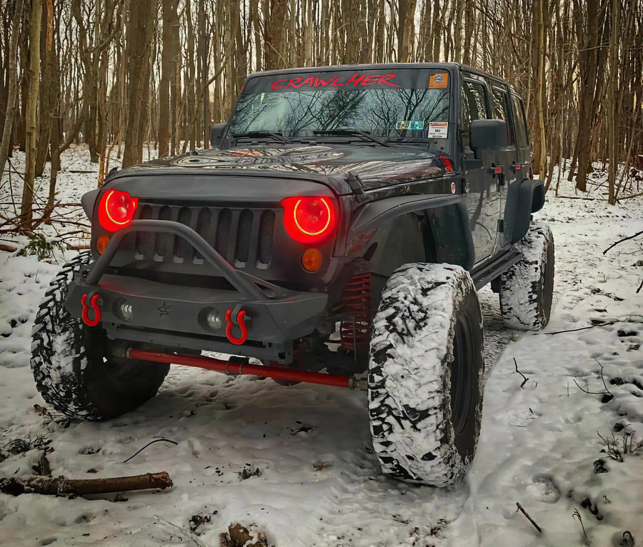 Three quarters view of a Jeep Wrangler JK with red LED headlight halos installed.