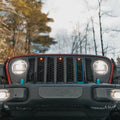 Front end of a Jeep Wrangler JL with amber Pre-Runner Style LED Grill Light Kit installed.