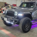 Jeep parked in a garage with multiple lighting products installed and turned on.
