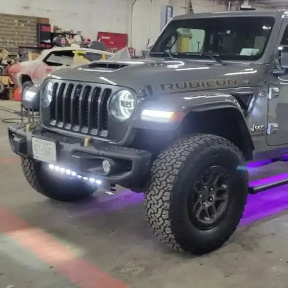 Jeep parked in a garage with multiple lighting products installed and turned on.