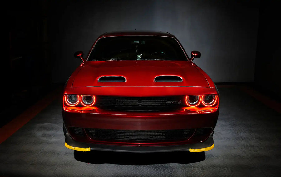 Front end of a red Dodge Challenger with red halo headlights.