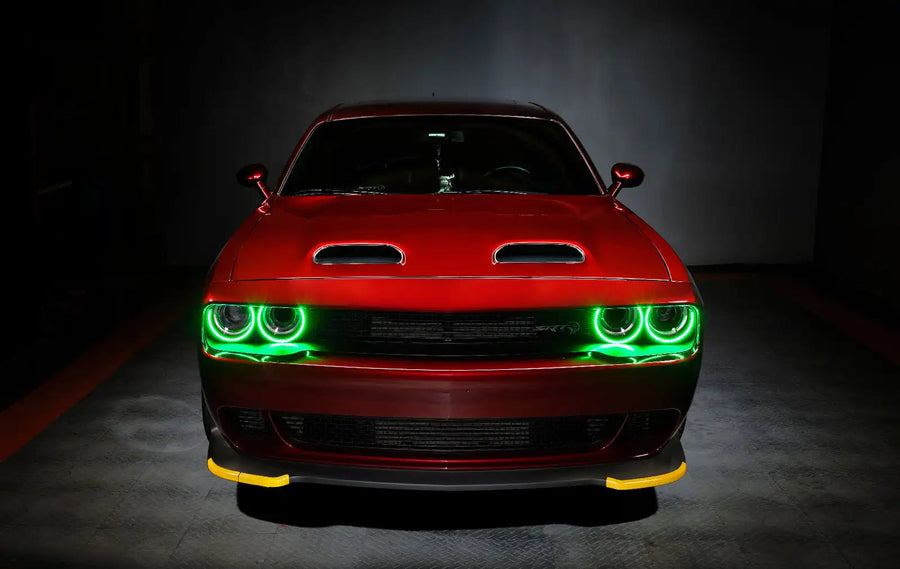 Front end of a red Dodge Challenger with green halo headlights.
