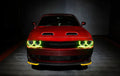 Front end of a red Dodge Challenger with yellow halo headlights.
