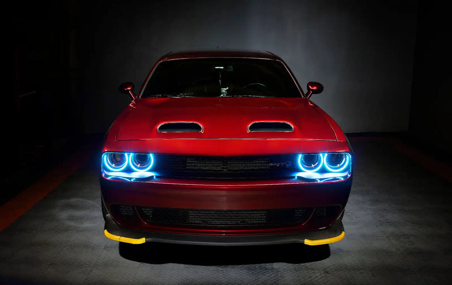 Front end of a red Dodge Challenger with cyan halo headlights.