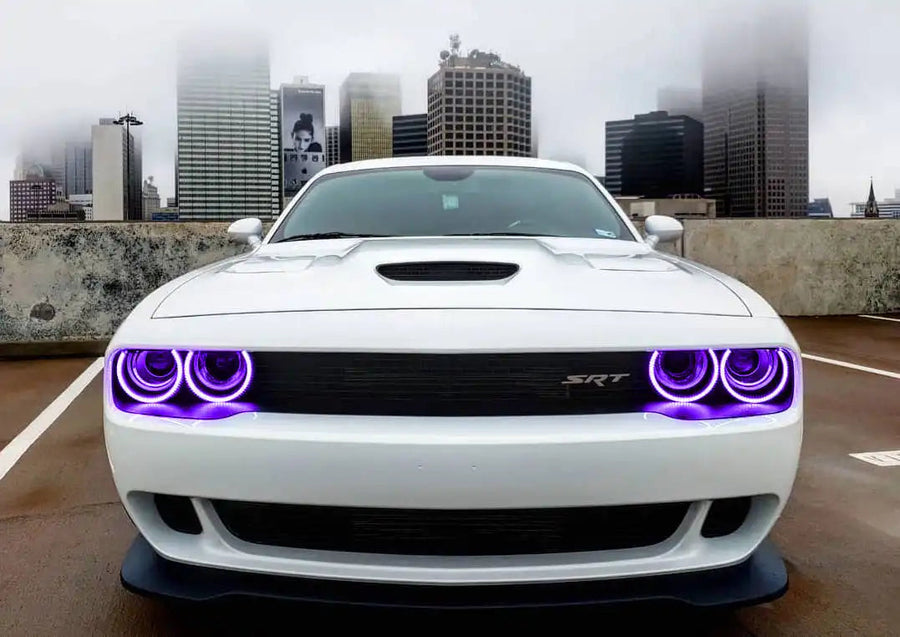 Front end of a white Dodge Challenger with purple LED headlight halo rings installed.