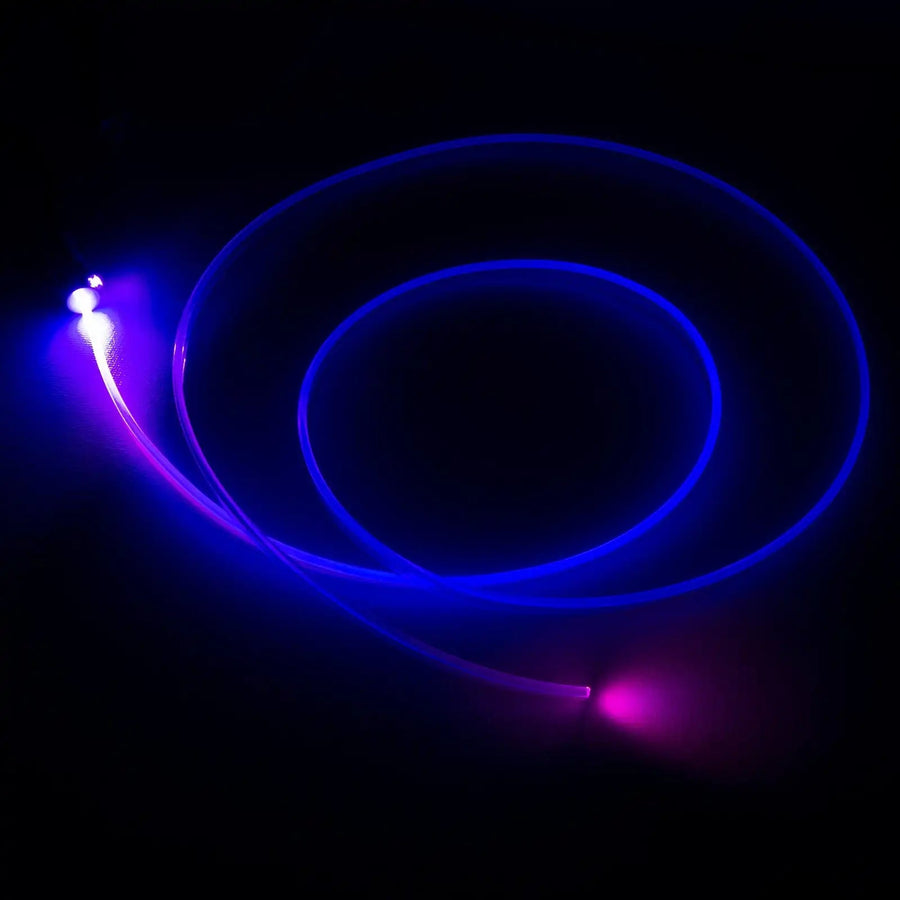 A fiber optic cable attached to a light head, glowing purple.