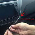An image of someone installing a fiber optic cable on the dashboard of a vehicle, with a red arrow pointing to a gap in the dashboard. Text on the image reads "insert along the gap."