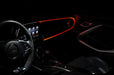 The dashboard of a car with ColorSHIFT Fiber Optic LED Interior Kit installed, glowing red.