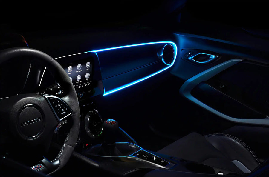 The dashboard of a car with ColorSHIFT Fiber Optic LED Interior Kit installed, glowing cyan.