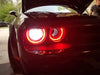 Close-up of red LED headlight halo rings installed on a Dodge Challenger.