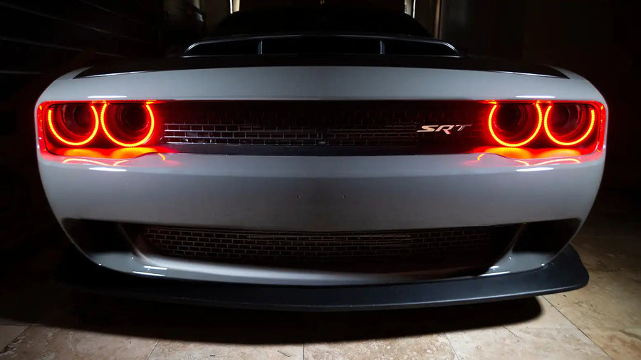 Front end of a Dodge Challenger with red halo headlights.