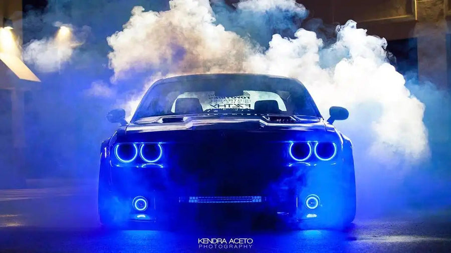Front end of a Dodge Challenger with blue LED headlight and fog light halo rings.