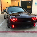 Black challenger parked outside with red halo headlights