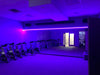 Workout room with purple LED lighting strips above the mirrors.