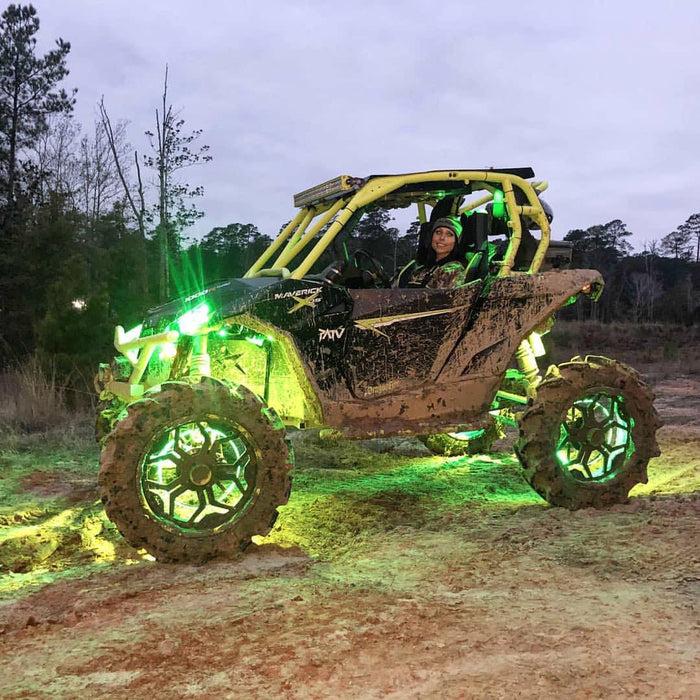 A side by side in the mud, with green LED lighting installed.