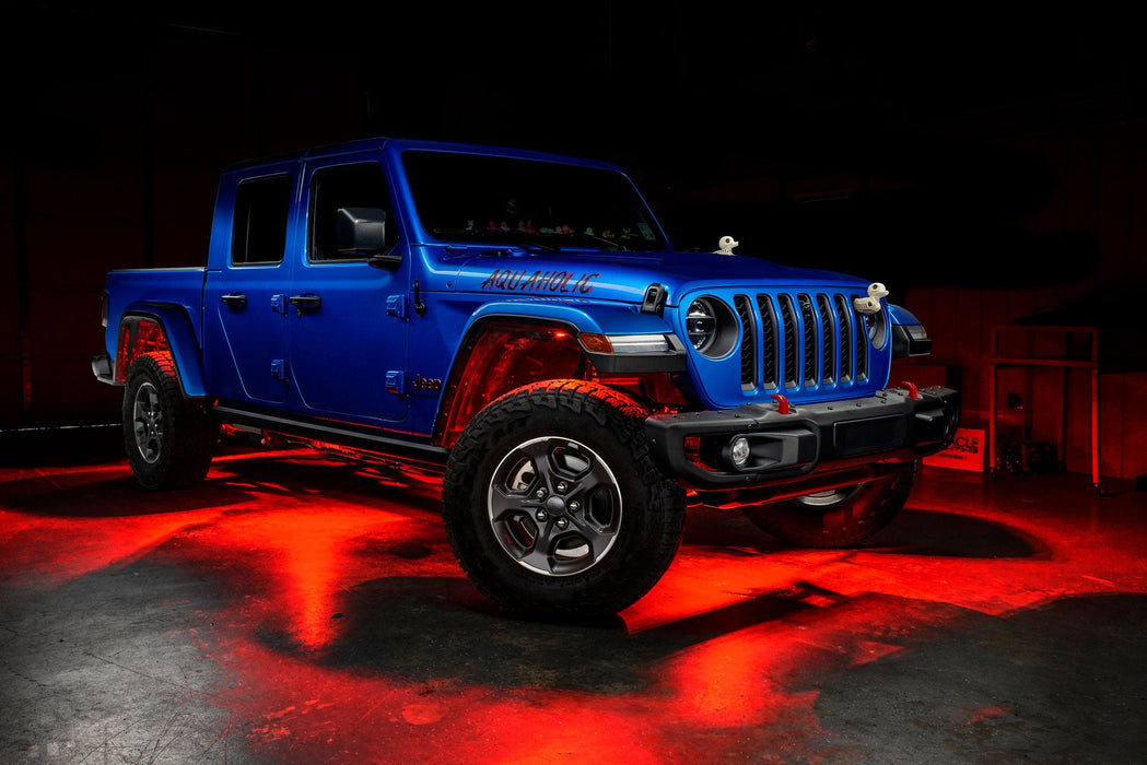 Three quarters view of a blue Jeep Gladiator JT with rock lights set to red.