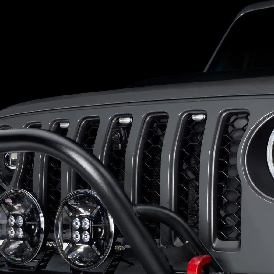 Close-up of a Universal Pre-Runner Style LED Grill Light Kit with clear lens installed on Jeep Wrangler.