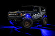 Three quarters view of wrapped Ford Bronco with blue LED rock lights installed